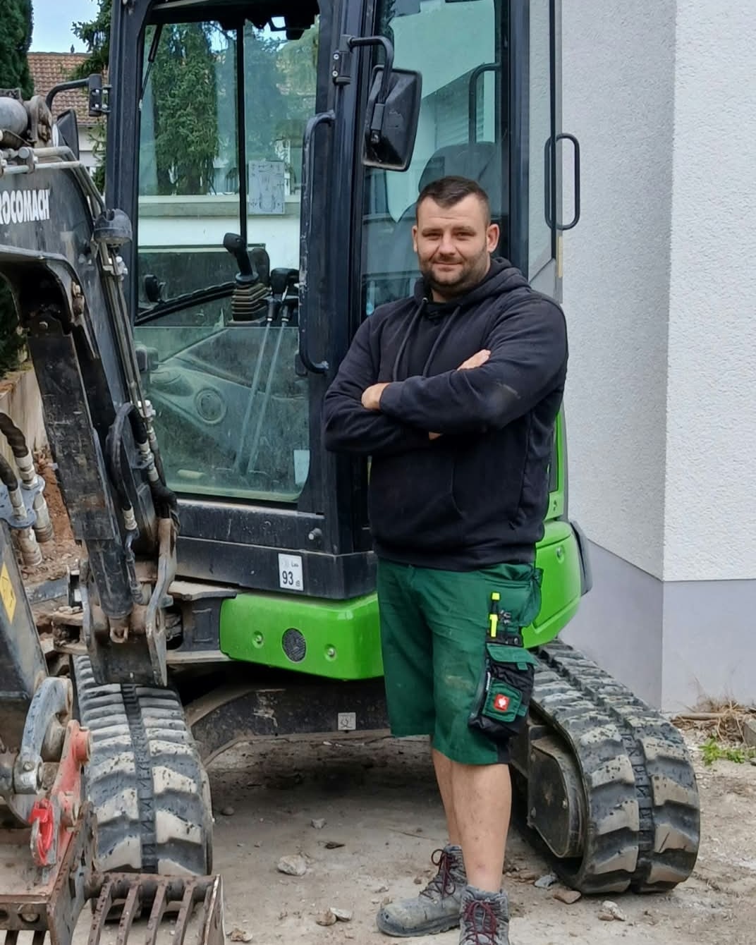 Thomas Leber, Inhaber von Thomas Leber Garten & Landschaftsbau, vor seinem Minibagger
