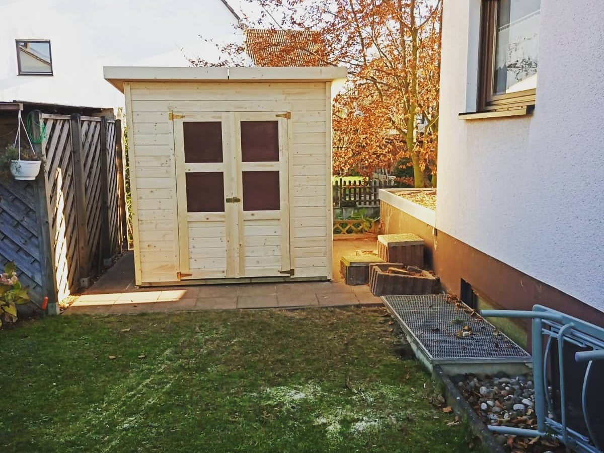 Hausrücken nachher: neues helles Gerätehaus an der Hauswand