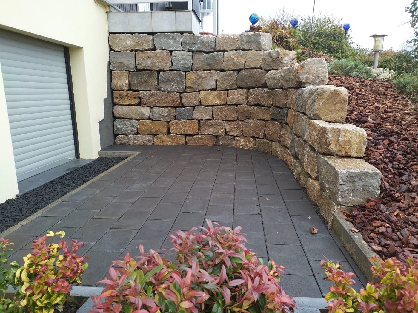 Nachher: gesetzte Natursteinmauer über neu verlegten Terrassenplatten